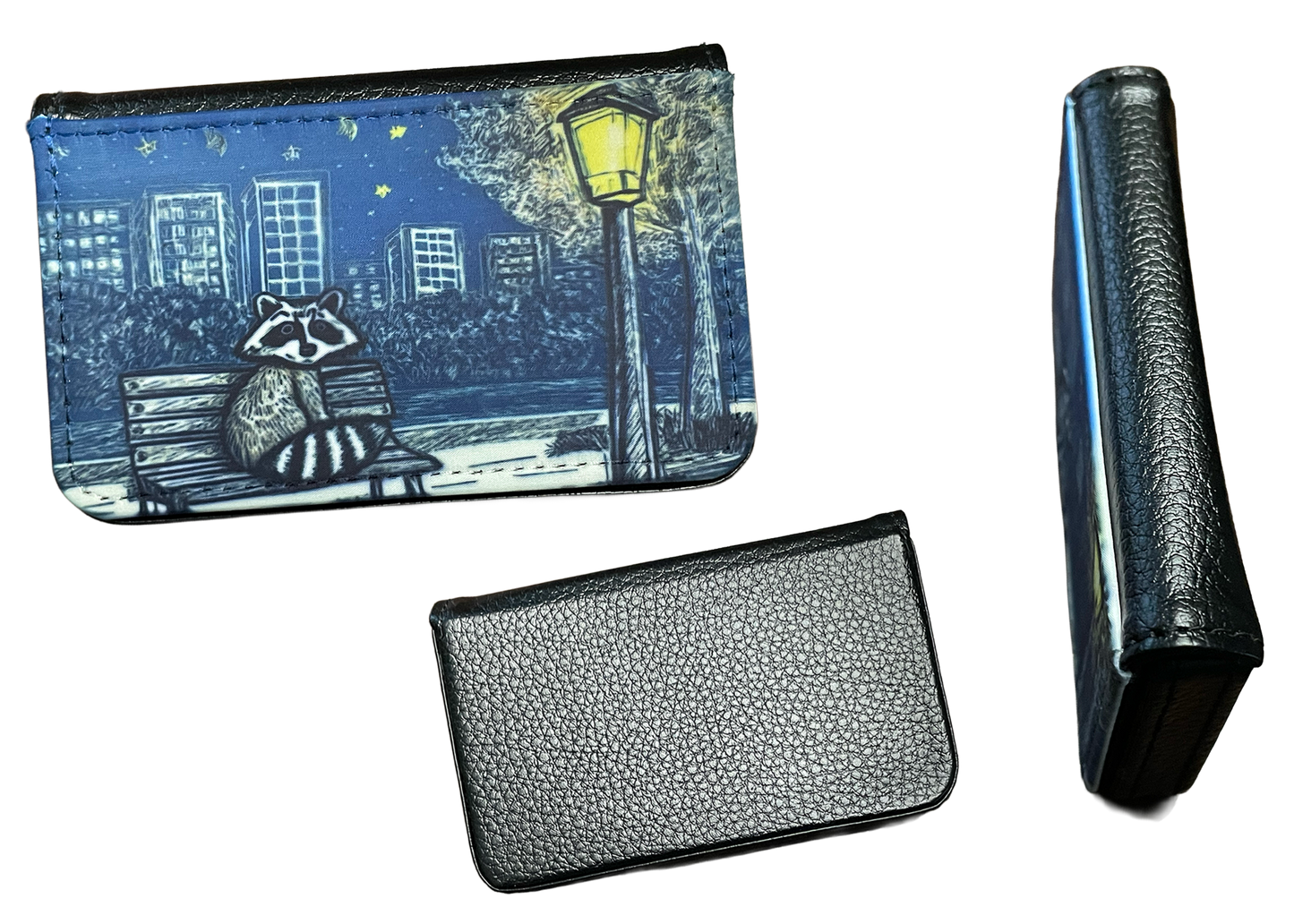 Small card holder with raccoon design, folded cardholder, and black leather wallet on a white background