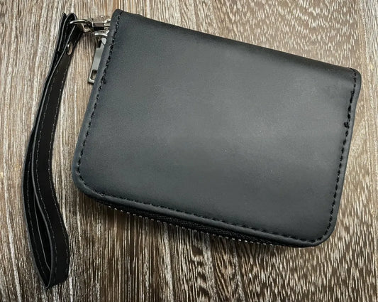 Black wristlet purse on a wooden surface