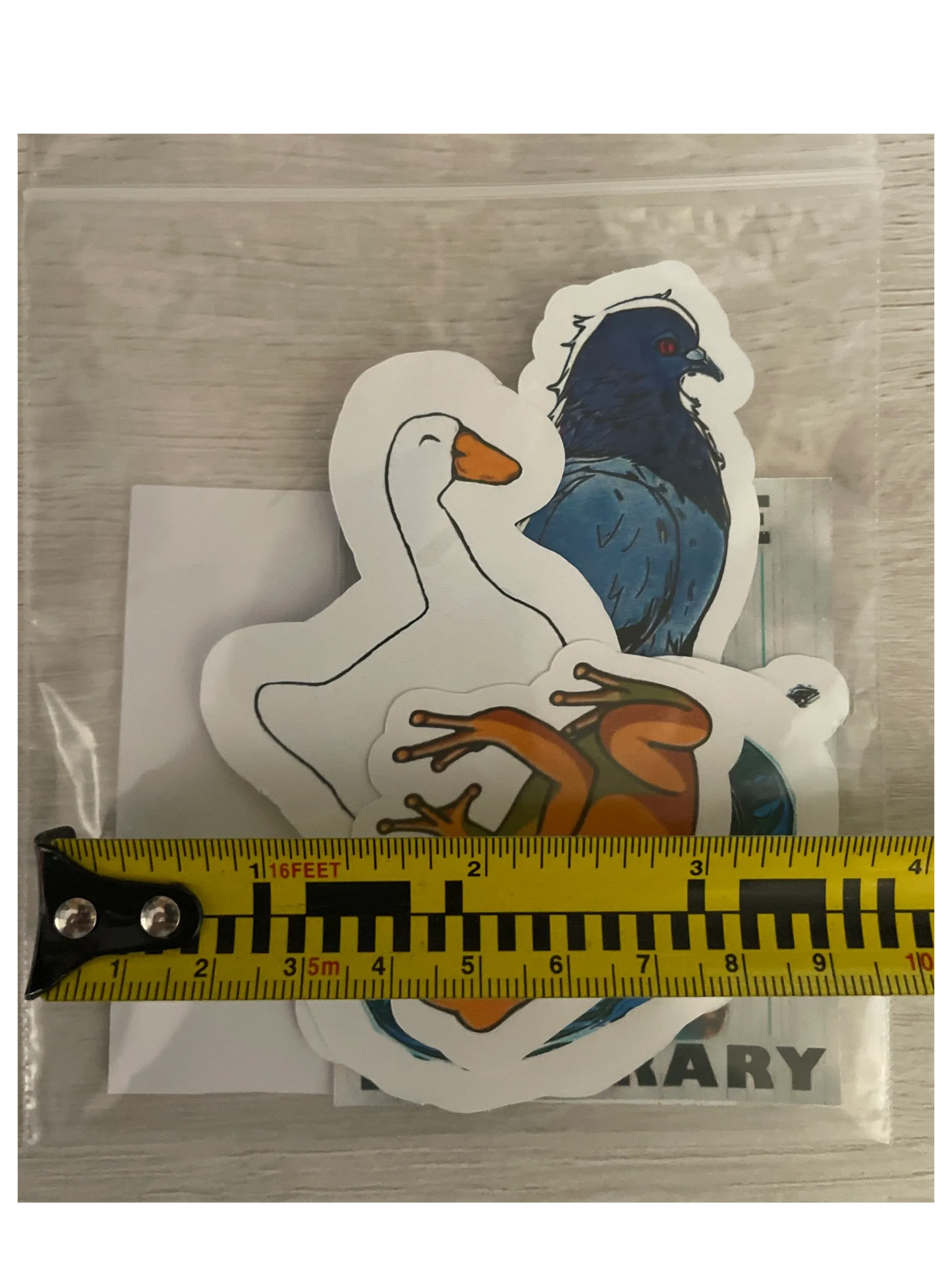 Three animal-shaped stickers (goose, bird, frog) on a clear background with a ruler for scale.